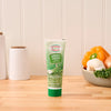 A tube of Gourmet Garden Green Onion Stir-In Paste sits on a wooden countertop in a kitchen setting.