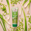A tube of Gourmet Garden Green Shallot herb blend is surrounded by fresh green onions and chopped shallots.