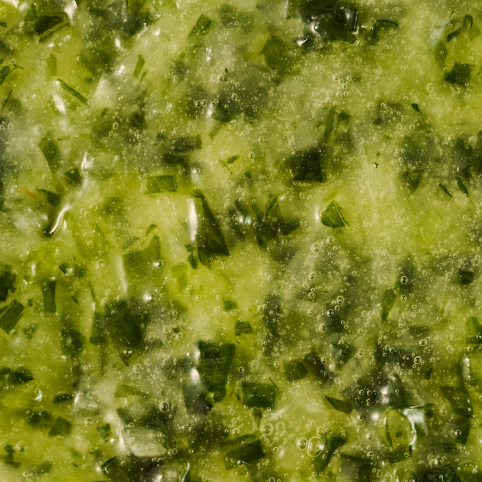 Close-up of a vibrant green herb sauce or marinade.