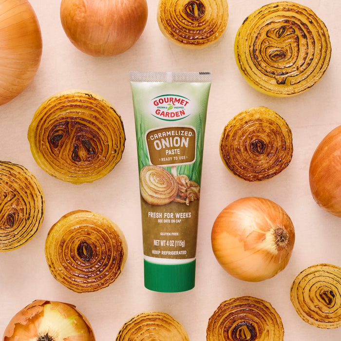 A tube of Simply Organic Onion Flavor Paste is centered among fresh and roasted onion slices.