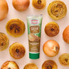 A tube of Simply Organic Onion Flavor Paste is centered among fresh and roasted onion slices.