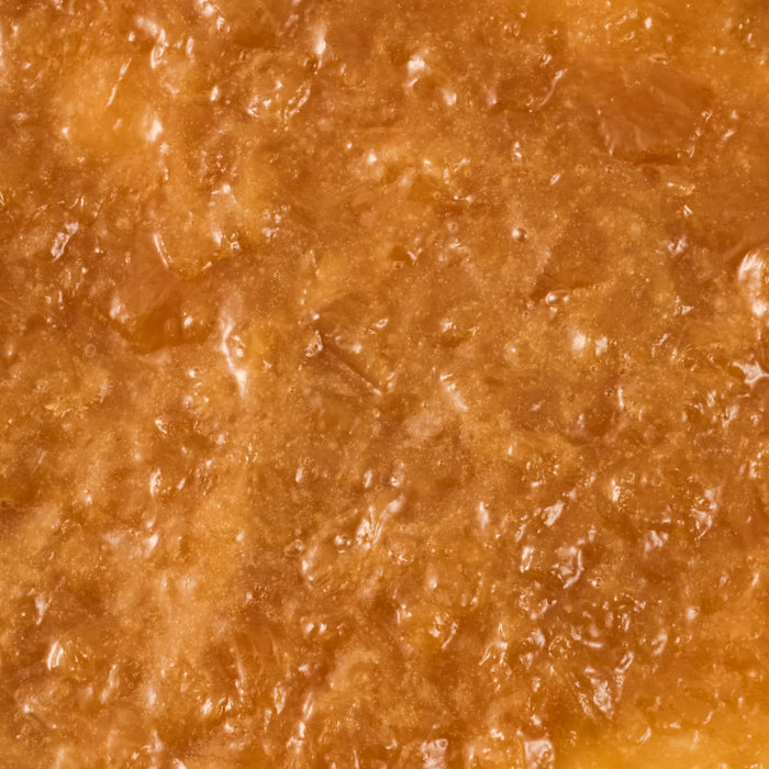 A close-up texture of a golden-brown, glazed surface.