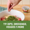 A hand sprinkles Gourmet Garden Italian Seasoning Blend into a bowl of ingredients.