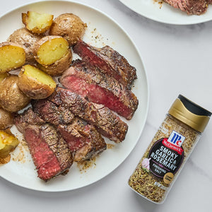 McCormick Smoky Garlic &amp; Rosemary Finishing Salt with a plate of steak and potatoes.