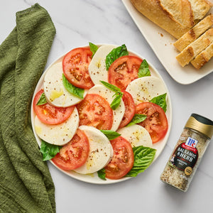 A plate of caprese salad with fresh mozzarella tomatoes and basil topped with McCormick Balsamic &amp; Herb Finishing Salt.