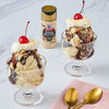 Two ice cream sundaes topped with whipped cream chocolate sauce and a cherry with a jar of McCormick Brown Butter Finishing Salt.
