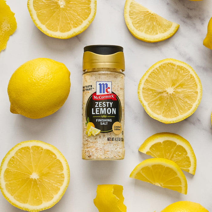A jar of McCormick Zesty Lemon Finishing Salt is surrounded by lemon slices.