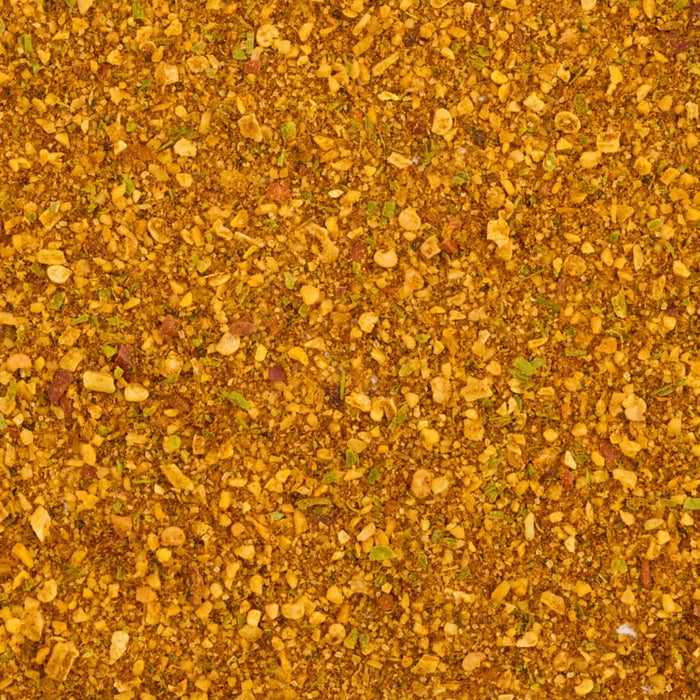 A close-up, top-down view reveals the coarse texture of the Mccormick Indian Style Seasoning, 5.33 Oz, showing a blend of golden spices, green herbs, and red chili flakes.
