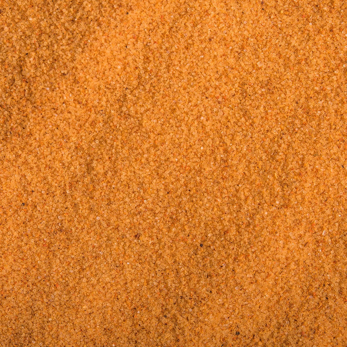A close-up texture of fine, orange-colored sand.
