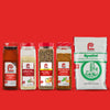 A collection of Spatini brand seasoning products are displayed against a red background.
