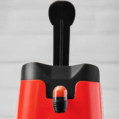 Close-up of a red and black dispenser on a gray background