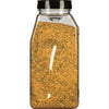 A glass jar filled with a yellow and green spice blend.