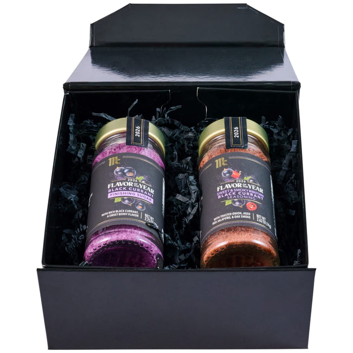 A black gift box displays two McCormick Flavor of the Year 2026 products, including the Mccormick Culinary Sweet &amp; Smoky Naturally Flavored Black Currant Seasoning and a Black Currant Finishing Sugar, nestled in black paper shred.