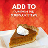 A slice of pumpkin pie with whipped cream on a white plate with the text Add to pumpkin pie soups or stews on a red patterned background.
