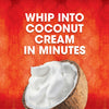 A coconut shell filled with whipped coconut cream is displayed against a red and orange patterned background promoting the ease of making coconut cream.