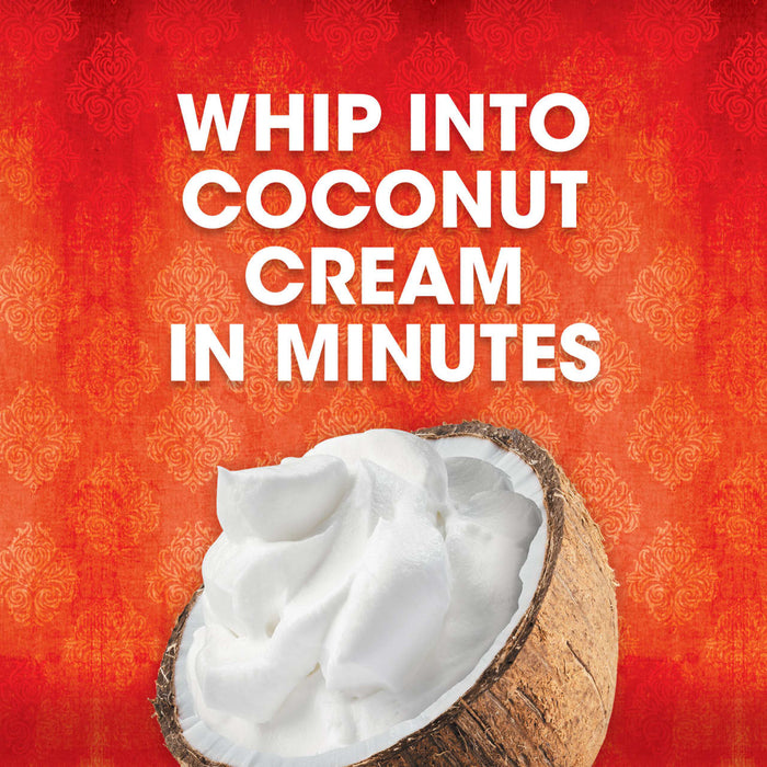 A coconut shell filled with whipped coconut cream is displayed against a red and orange patterned background promoting the ease of making coconut cream.
