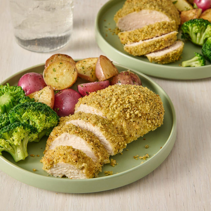 A plate of breaded chicken with potatoes and broccoli.