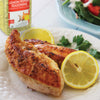 Two pieces of lemon pepper seasoned chicken breast with lemon wedges on a white plate.