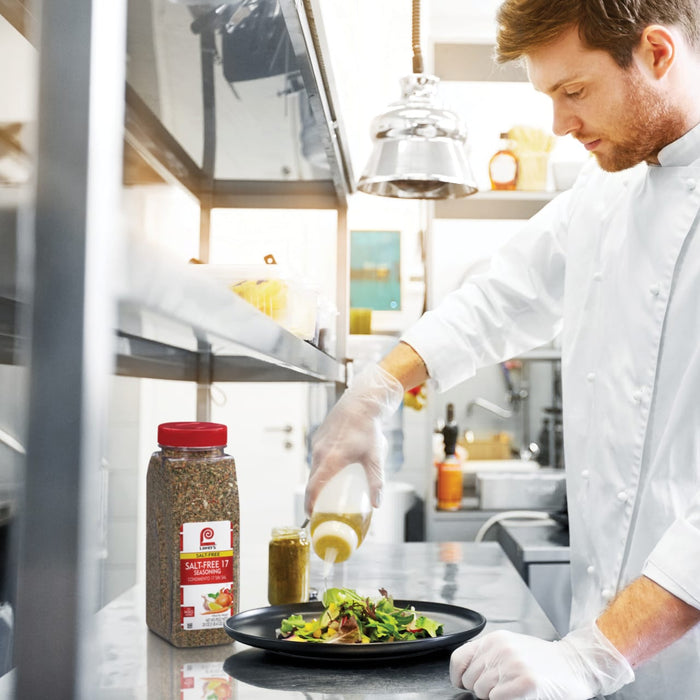 A chef is preparing a salad with Lawry's Salt-Free 17 Seasoning.