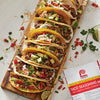 A close-up of Lawry's Taco Seasoning Mix with a plate of delicious tacos.