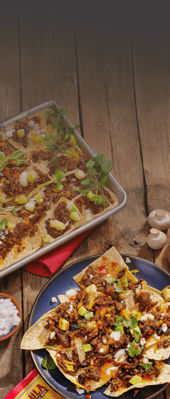 Nacho platter with various toppings on a wooden table