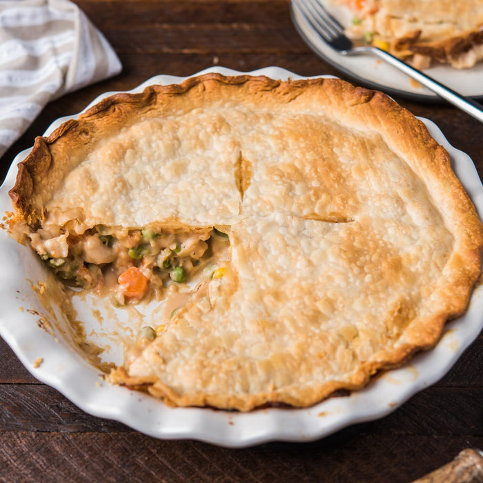 A close-up of a chicken pot pie with a flaky crust and a creamy filling.