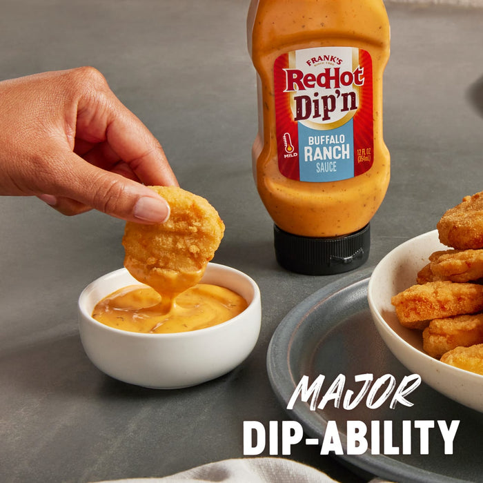 ["A hand dips a crispy chicken finger into a bowl of Frank's RedHot Dip'n Buffalo Ranch Sauce."]