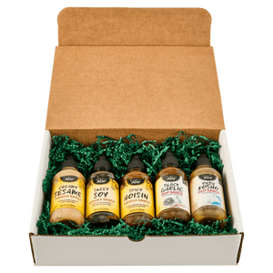 A gift box containing five bottles of different flavors of BBQ sauce.