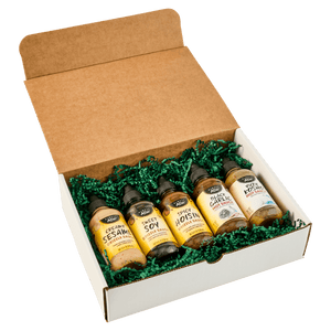 A gift box containing five bottles of different flavors of BBQ sauce from a brand called BBQ Island.
