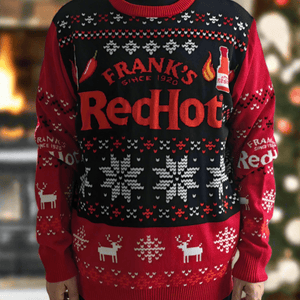 A person wearing a Frank's RedHot ugly Christmas sweater with snowflakes, reindeer, and chili pepper designs.
