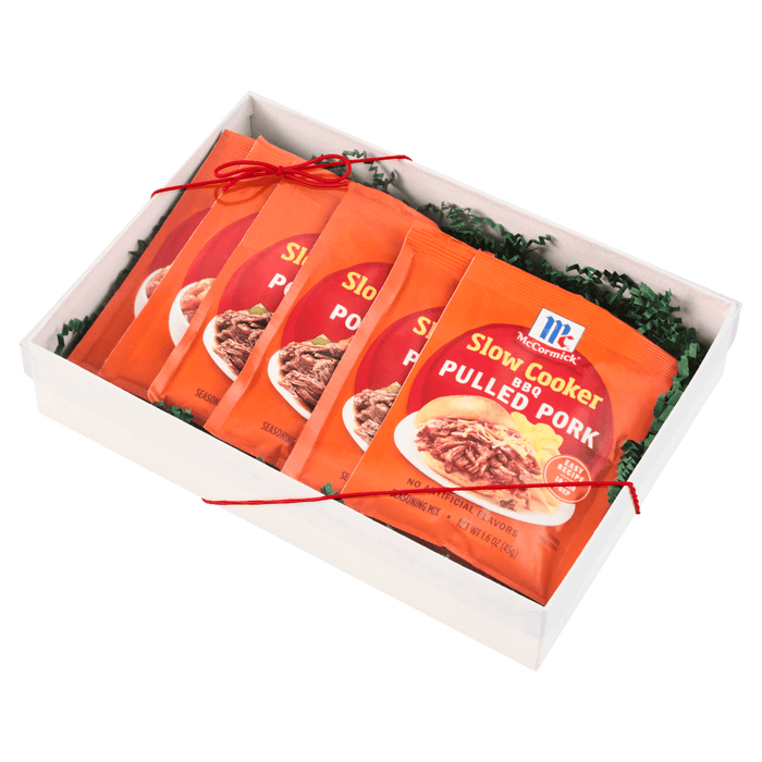A gift box containing multiple packets of McCormick Slow Cooker Pulled Pork seasoning mix.