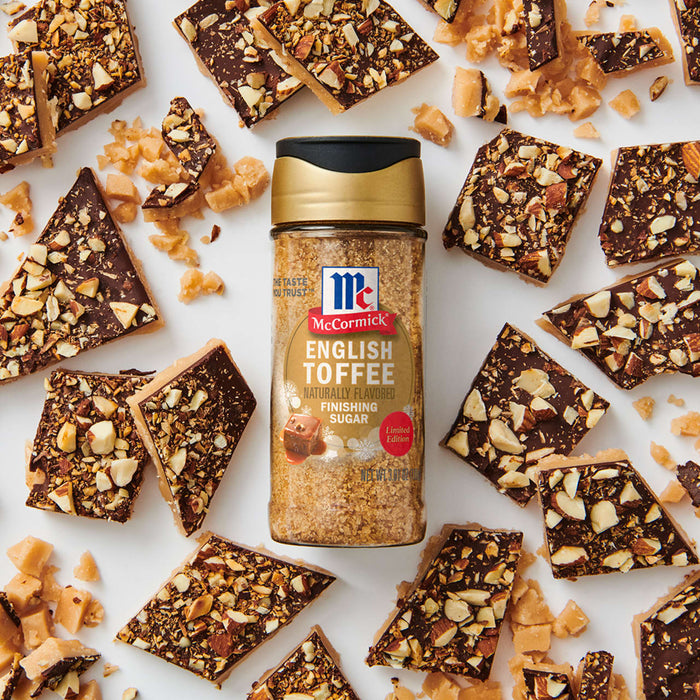McCormick English Toffee Seasoning is displayed amidst scattered pieces of toffee bark, highlighting its use in enhancing dessert flavors.