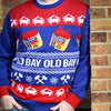 A person wearing a festive Old Bay seasoning themed sweater with crabs and spice containers.