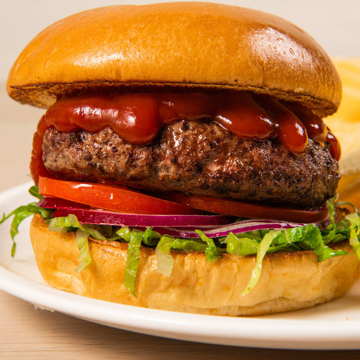 A juicy burger with fresh toppings and ketchup on a brioche bun.