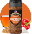 McCormick Grill Mates Brown Sugar Bourbon seasoning bottle with a glass of bourbon, red pepper, and sugar on an orange background.