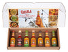 A Cholula Hot Sauce Variety Pack Gift Set is displayed in an open box, showcasing seven different flavors: Sweet Habanero, Extra Hot, Chili Lime, Original, Chipotle, Chili Garlic, and Green Pepper.