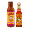 A bottle of Cholula Cooking Sauce in Cochinita Pibil flavor stands next to a bottle of Cholula Original Hot Sauce against a black background.