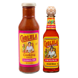 A bottle of Cholula Cooking Sauce in Cochinita Pibil flavor stands next to a bottle of Cholula Original Hot Sauce against a black background.