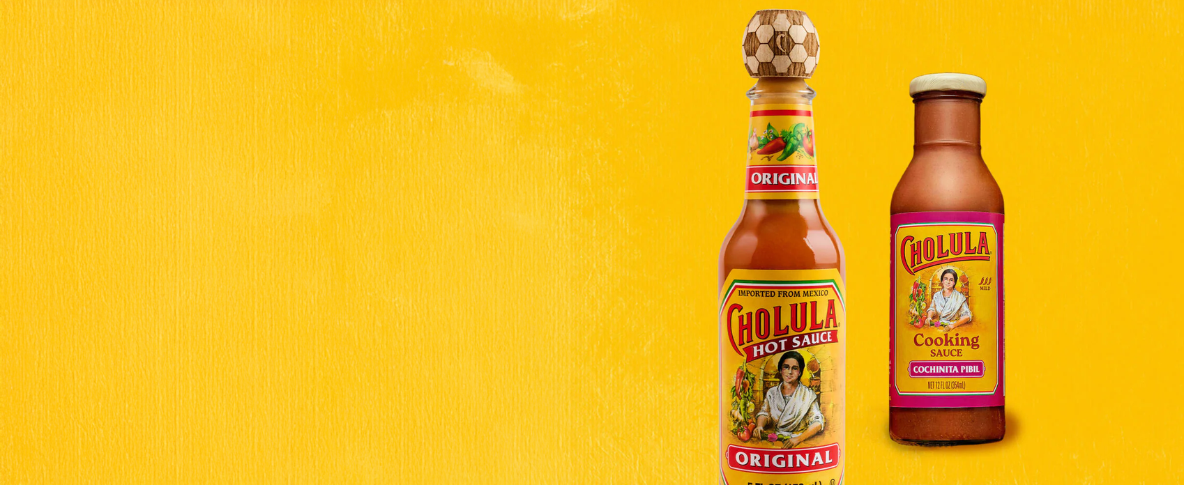 Two bottles of Cholula hot sauce on a yellow background
