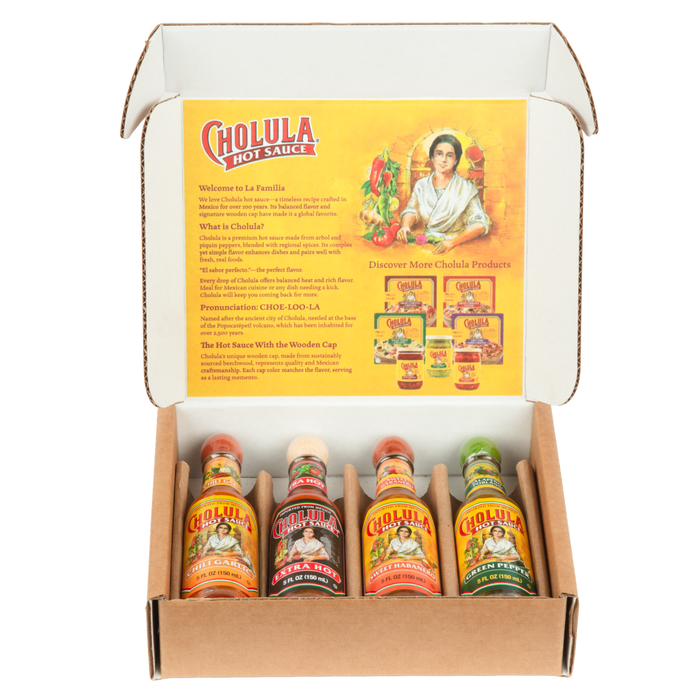 A cardboard gift box displays four different flavors of Cholula Hot Sauce: Chili Garlic, Extra Hot, Sweet Habanero, and Green Pepper.