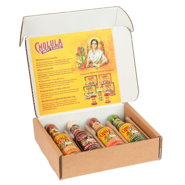 An open gift box displays four different bottles of Cholula Hot Sauce, including Chili Garlic, Extra Hot, Sweet Habanero, and Green Pepper flavors.