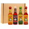 Four bottles of Cholula Hot Sauce, a McCormick brand, are arranged in a row in front of a cardboard box, showcasing the Chili Garlic, Extra Hot, Green Pepper, and Sweet Habanero flavors.