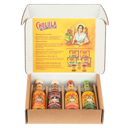 A Cholula Hot Sauce gift set is displayed in an open box, showing four different flavors: Original, Extra Hot, Sweet Habanero, and Green Pepper.
