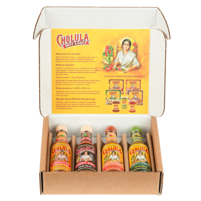 A Cholula Hot Sauce gift set is displayed in an open box, showing four different flavors: Original, Extra Hot, Sweet Habanero, and Green Pepper.