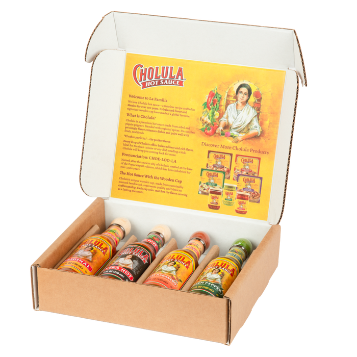 An open gift box displays a variety pack of Cholula Hot Sauce, featuring the Original, Extra Hot, Sweet Habanero, and Green Pepper flavors.