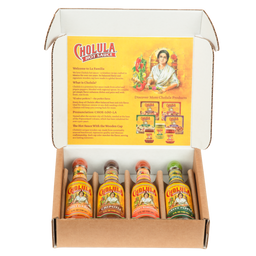 An open gift box displays a Cholula Hot Sauce Variety Pack, featuring Chili Garlic, Chipotle, Sweet Habanero, and Green Pepper flavors, with an informational insert about the brand's history.