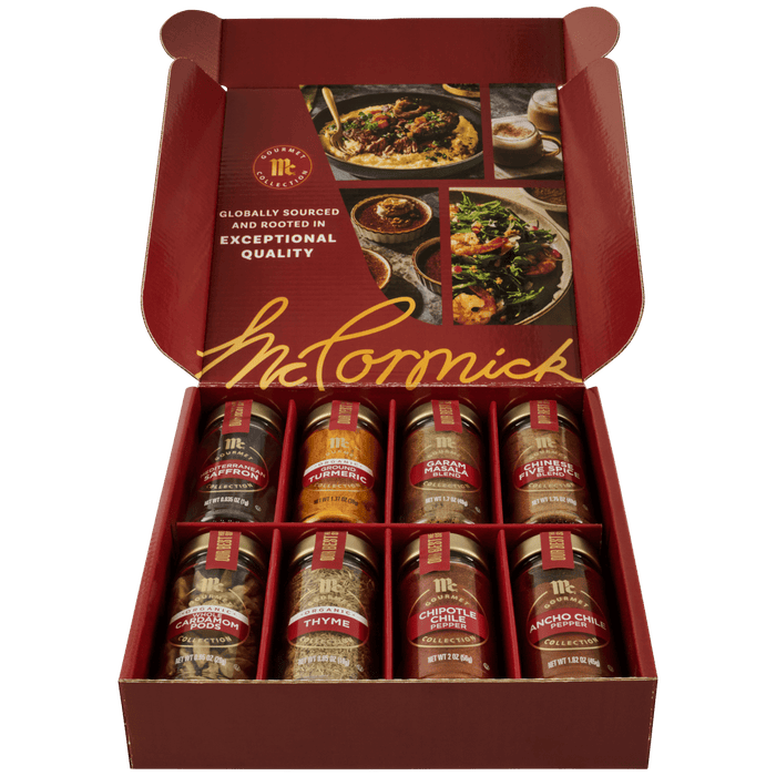 An open red gift box of the Gourmet Bundle Global Exploration Dtcmckvb from McCormick displays eight assorted spices from the Gourmet Collection, including Saffron, Turmeric, and Garam Masala.