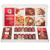 An open McCormick spice gift set showcases a wide assortment of products, including jars of Basil, Paprika, and Ginger, bottles of Vanilla Extract, and packets of Taco and Chili seasoning.