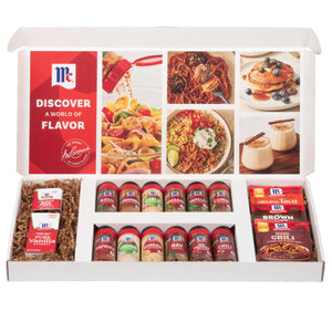 An open McCormick spice gift set showcases a wide assortment of products, including jars of Basil, Paprika, and Ginger, bottles of Vanilla Extract, and packets of Taco and Chili seasoning.