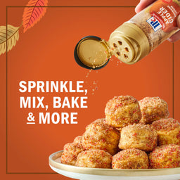 A hand sprinkles McCormick Pumpkin Pie Spice onto a stack of baked goods, highlighting its versatility for sprinkling, mixing, baking, and more.